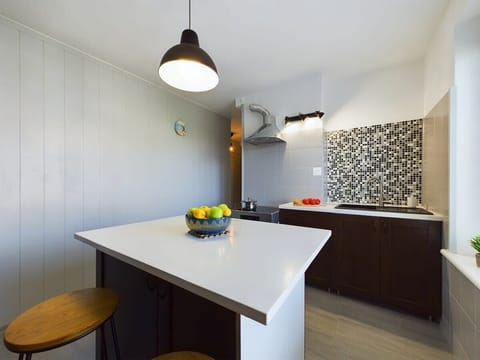 Functional kitchen with a modern breakfast bar and sleek stools.


