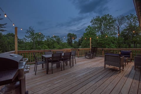[Walk out deck] Dining table, patio furniture, rocking chairs, grill, cooler