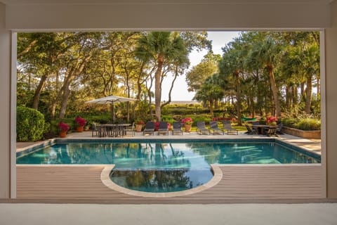 The vast living area unfolds before you, seamlessly extending to an inviting pool, sun-kissed deck, and a private pathway that leads directly to the  beach.