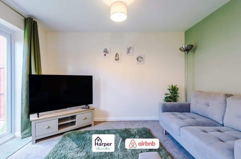 A welcoming open-plan living space filled with natural light, featuring modern sofas, stylish décor, and large windows overlooking the garden.