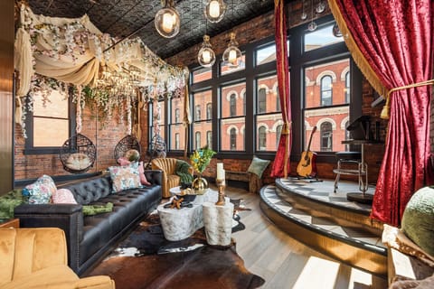 - Stunning living room with bold décor and city views   - Cozy seating, flower canopy and hanging chairs for relaxing   - Perfect stay with unique style and photo-worthy design
