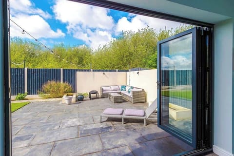 This is the view from the conservatory looking out onto the sun lounger and the seating area outdoors