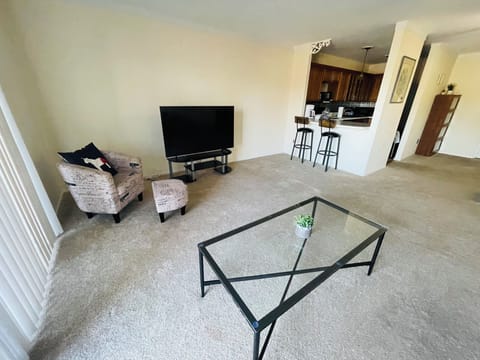 The living room comes furnished with essential pieces, including a comfortable sofa, a coffee table, and a TV stand, providing immediate comfort upon move-in.