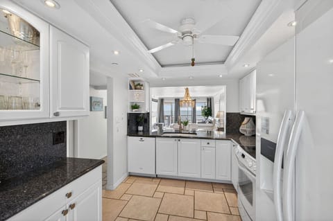 Bright kitchen w/ white cabinetry, dark counters & a functional layout.