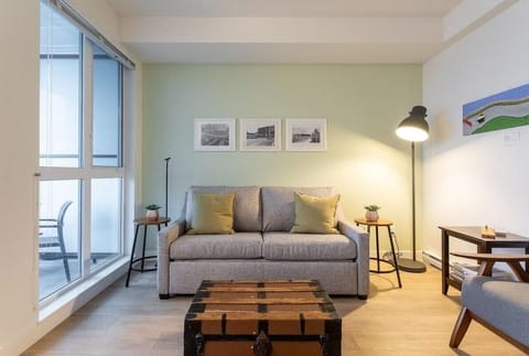 Cozy living room with natural light, double sofa bed, and stylish comfort