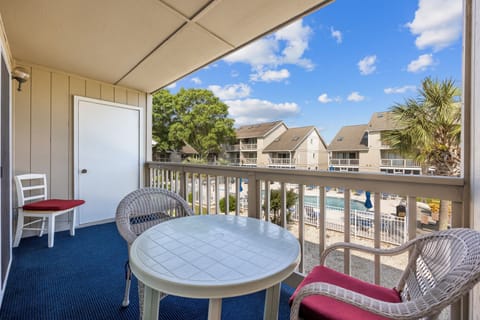 Relax on the carpeted patio featuring cozy seating and enjoy stunning pool views—perfect for unwinding with your morning coffee or evening drink.