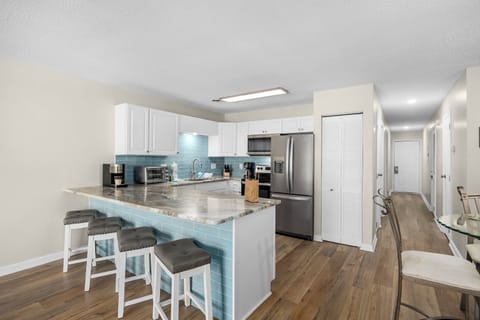 Fully equipped kitchen with a stylish breakfast bar—perfect for relaxing or entertaining during your stay.