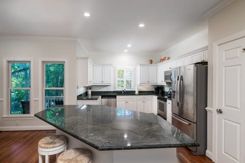 A large island in the kitchen with 2 stools