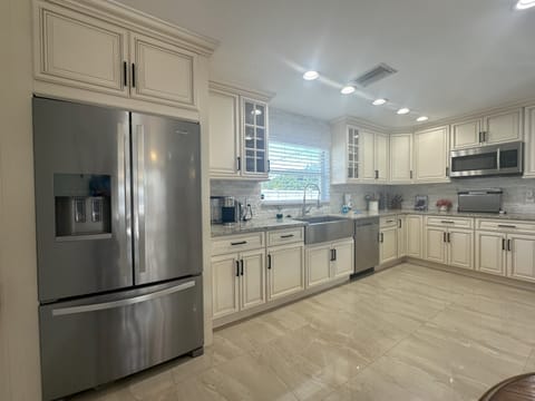 Fully equipped kitchen with refrigerator, stove, microwave, air fryer and more.