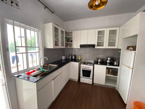 A fully equipped kitchen featuring an oven, microwave, kettle, and a spacious fridge available for use at any time.