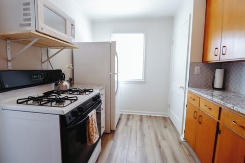 Kitchen with stove, refrigerator and microwave oven. 