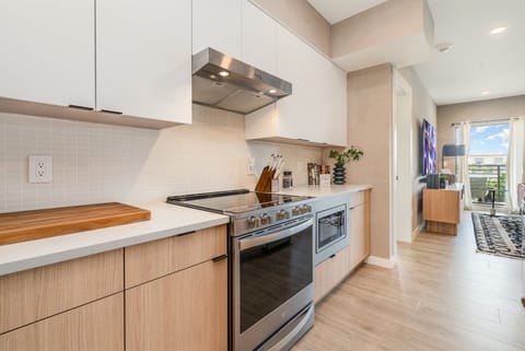 Fully equipped modern kitchen featuring culinary essentials, stainless steel appliances, and island bar seating.