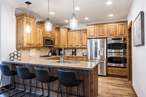 - Cook with ease in the fully equipped modern kitchen
- Stainless steel appliances and wood cabinetry stand out
- Enjoy meals at the granite island with bar seating