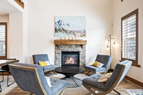 - Gather around the cozy stone fireplace with modern chairs  
- Relax in a stylish living area perfect for conversation  
- Enjoy a warm inviting space designed for comfort and charm