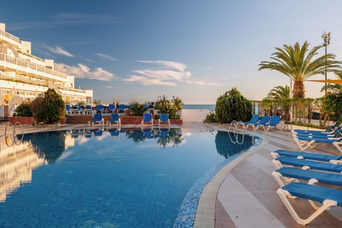 Lounge poolside and enjoy serene reflections under open skies.