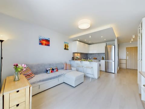 A spacious living room with a large sectional sofa, dining area, and an open-concept kitchen with neutral tones.