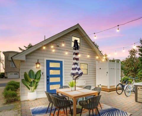 Unwind in this beautifully lit outdoor seating area, complete with a dining set, string lights, and a hot tub for perfect evenings.