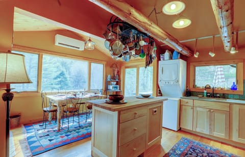 Kitchen with butcher block island, pot rack, stack washer / dryer and sink