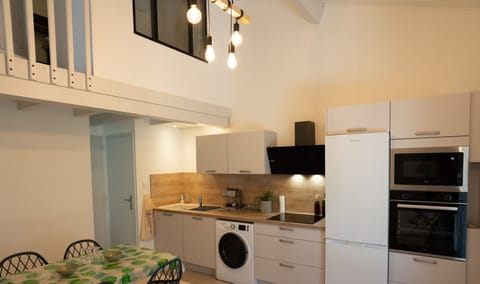 Air-conditioned living room with fitted kitchen, dining table and TV.