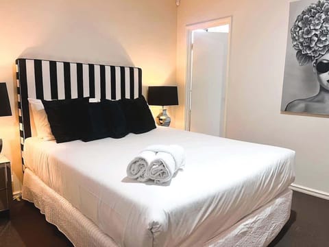 Comfortable bedroom with a striking headboard, fresh bedding, and thoughtful touches for your comfort.
