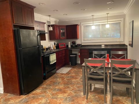 Stylish granite kitchen includes dishes, cookware, microwave, coffeemaker, dishwasher soap, baking pans, etc. 