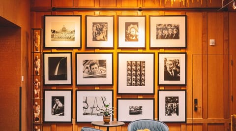 A wall adorned with an array of framed photographs and art adds a personal touch to our lobby, creating a space that's as much a gallery as it is a welcoming area.