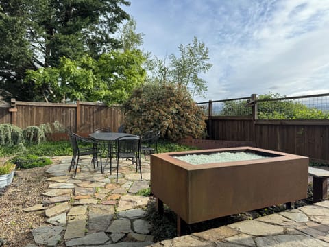 The backyard features a fire pit and dining table.