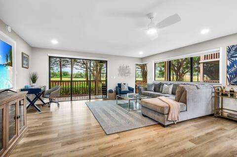 Modern living: Open concept living & dining area with large windows for ample natural light, and views for the golf course. The living room features a full-sized sleeper sofa, personal desk, and smart streaming TV with cable.