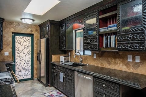 Fully stocked kitchen with granite counter tops and hand-carved cabinetry.