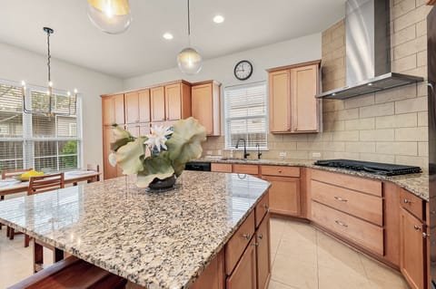 Kitchen features granite countertops, modern cabinetry, large center island.