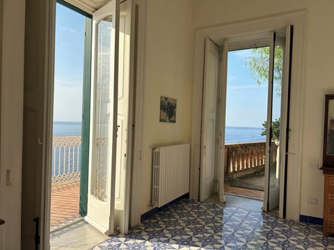 Corner of Bedroom 1 showing outdoor access to front balcony and private garden.