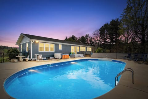 Back of house with pool and hot tub.