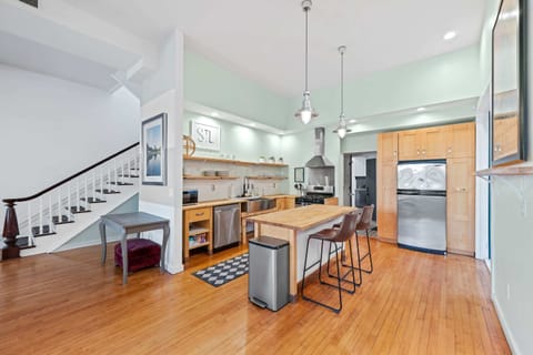Step into this cozy kitchen featuring a rustic table, a sleek refrigerator, and charming stairs leading to who-knows-where! 🏡✨ #HomeSweetHome #KitchenGoals