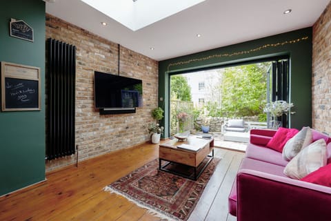 A second living room adjacent to the open-plan kitchen with concertina doors opening to the garden