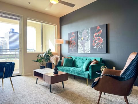Modern Cosmopolitan Style Apartment with a stunning downtown view Living room with a sofa, and a 50" Smart TV with (Netflix, Hulu, Disney+ we logged them remotely) included for free.