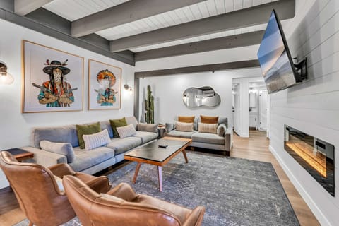 A stylish living room is the perfect spot to kick back and unwind with plush furnishings, a 65” Smart TV, and an electric fireplace creating a warm ambiance.