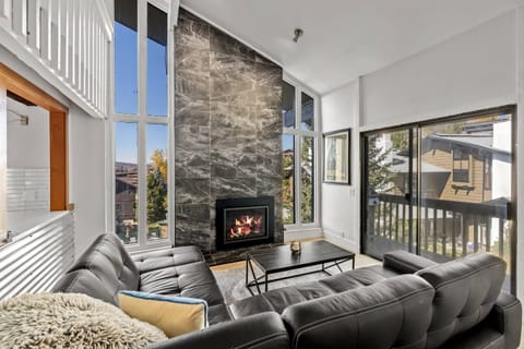 Gorgeous fire place in the living room, with floor to ceiling windows, a pass through to the kitchen, and easy access to the deck.