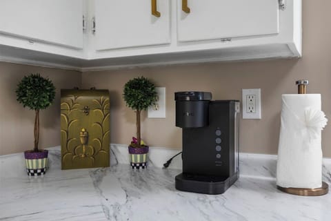 Start your mornings refreshed with this well-equipped coffee nook, featuring a sleek, modern coffee maker and charming decorative touches.