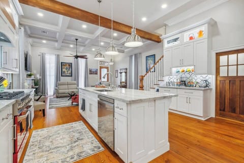 Spacious kitchen with high 12' ceilings, boasting a gas commercial range and a coffee bar complete with a frother, French press, drip coffee maker with syrups, and an electric tea kettle. There's also a separate walk-in pantry with a microwave.