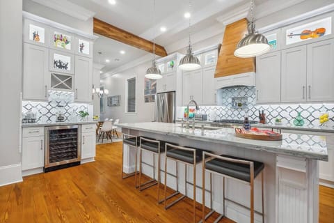 Large kitchen with large island seating for four, 12' ceilings, red gas commercial range and wine bar.