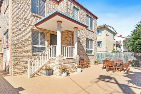 Walk through the sweeping paved outdoor patio area at the front entrance to the house which is set back from the street, accommodating a sense of calm and privacy. 

