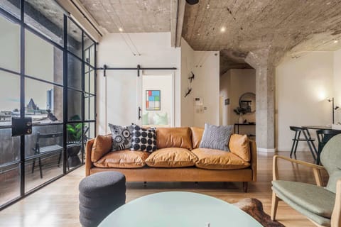 Stylish living room with natural light, city views, and a cozy leather sofa for relaxing