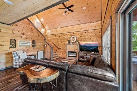 The living room includes a large Smart TV, electric fireplace, ceiling fan, and high ceilings.