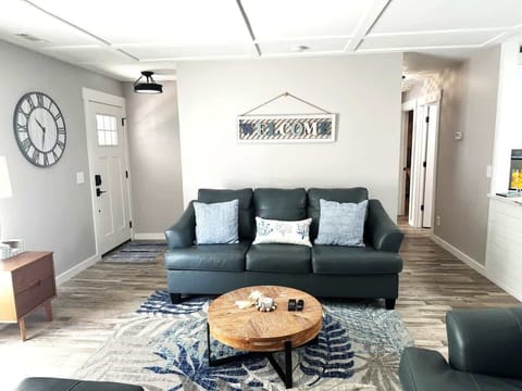 A bright, airy living space featuring a comfortable navy leather sofa.