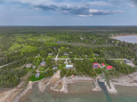Aerial view of Len Cove and the quiet beauty of Howdenvale—Lake Huron’s sparkling shoreline and lush forest set the scene for a peaceful retreat.

