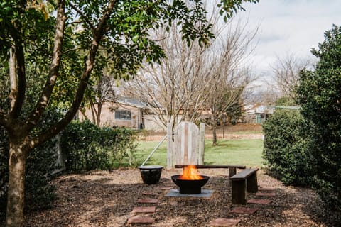 The backyard offers a serene escape with lush greenery. Enjoy a cosy night under the stars around the fire pit.
