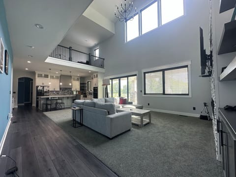 2 story great room with double sided fireplace, sectional and smart tv.