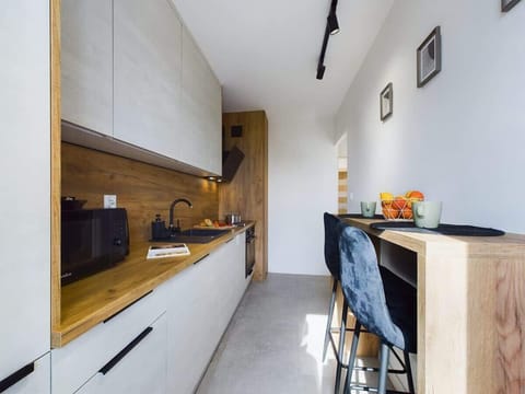 The kitchen's sleek design includes all necessary cookware and utensils. 