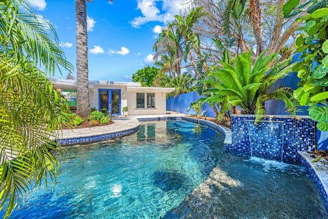A gentle waterfall cascades into the pool beside the Baja shelf—perfect for lounging in sun-kissed shallows.