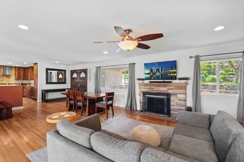 First Living Area (AC, ceiling fan, TV, large windows, dining area, fireplace)